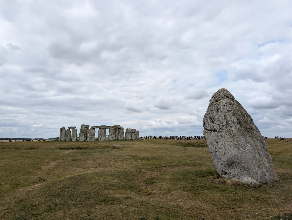 The Heel Stone with the circle behind it, seen on a Stonehenge tour from London, Wiltshire